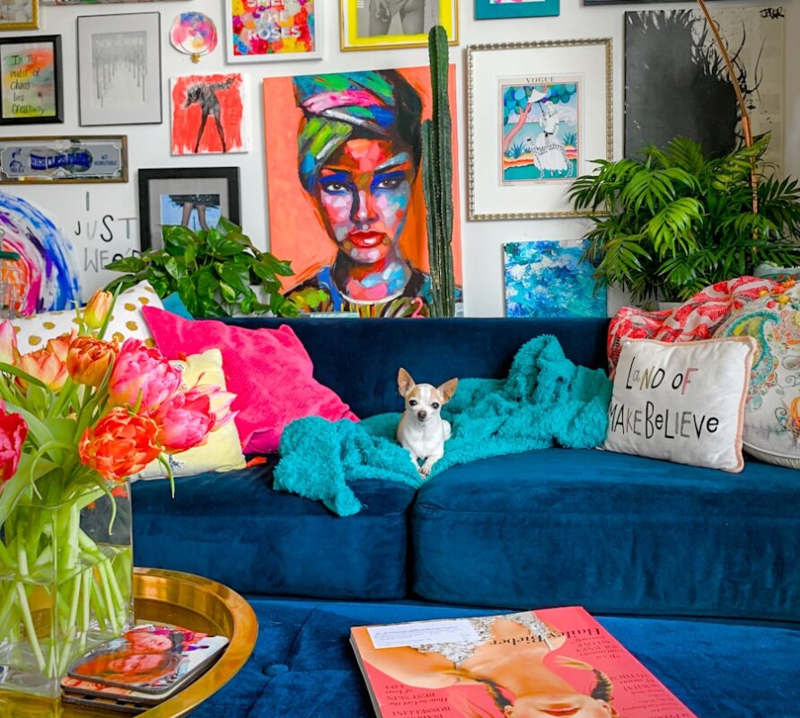 a living room filled with a blue couch and lots of pictures on the wall